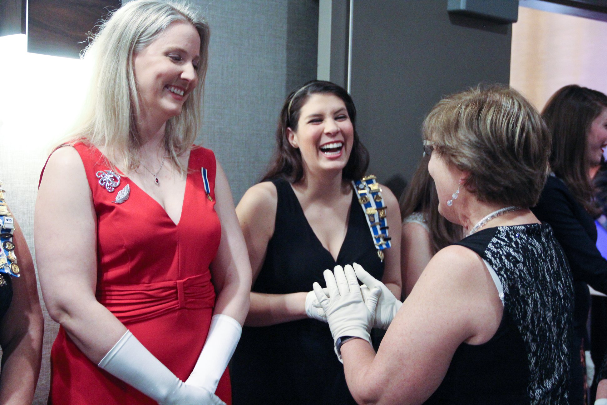 Women in formal attire greeting each other